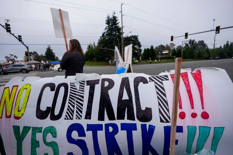 13-year Boeing employee Denise Strike waves a picket sign while striking with other employees after union members voted to reject a contract offer, Sunday, Sept. 15, 2024, near the company's factory in Everett, Wash. (AP Photo/Lindsey Wasson)