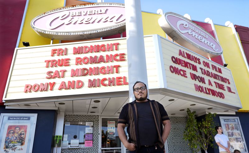 Cinephile Miles Villalon poses near the marquee of the New Beverly Cinema revival theater, Friday, Aug. 9, 2024, in Los Angeles. (AP Photo/Chris Pizzello)