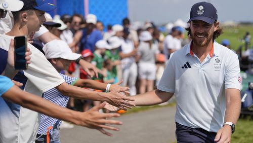 Tommy Fleetwood, of Great Britain, taps hands with fans as he walks to the 15th tee during the second round of the men's golf event at the 2024 Summer Olympics, Friday, Aug. 2, 2024, at Le Golf National in Saint-Quentin-en-Yvelines, France. (AP Photo/George Walker IV)