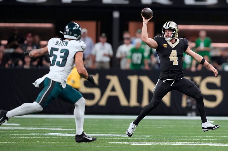 New Orleans Saints quarterback Derek Carr (4) fakes a pass as she scrambles against Philadelphia Eagles linebacker Zack Baun (53) in the second half of an NFL football game in New Orleans, Sunday, Sept. 22, 2024. (AP Photo/Gerald Herbert)