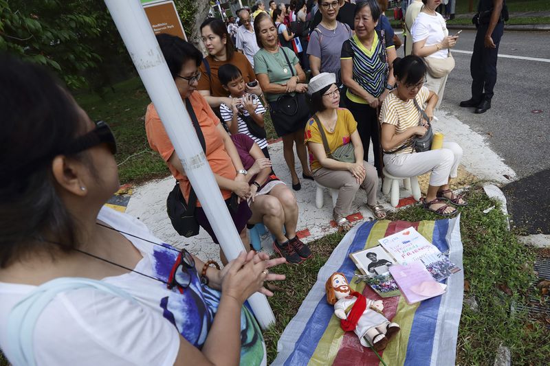 People wait for Pope Francis to arrive outside St Theresa's Home in Singapore, Friday, Sept. 13, 2024.(AP Photo/Suhaimi Abdullah)