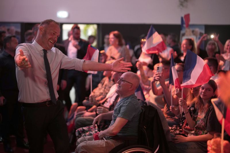 Local far-right mayor Steeve Briois, left, reacts after the release of projections based on the actual vote count in select constituencies , Sunday, June 30, 2024 in Henin-Beaumont, northern France. France's high-stakes legislative elections propelled the far-right National Rally to a strong but not decisive lead in the first-round vote Sunday, polling agencies projected, dealing another slap to centrist President Emmanuel Macron. (AP Photo/Thibault Camus)