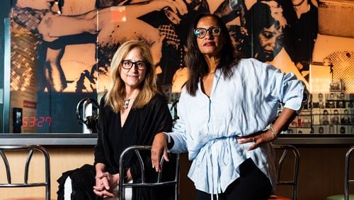 CEO Jill Savitt, left, and Chief Program Officer Kama Pierce of the National Center for Civil and Human Rights, pose at an exhibit designed to immerse visitors in a civil rights era lunch counter sit-in protest in Atlanta on Thursday, July 11, 2024. (Seeger Gray / AJC)