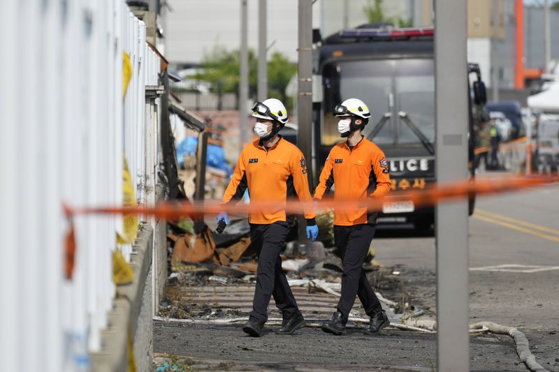 Firefighters walk near the debris at the site of a burnt battery manufacturing factory in Hwaseong, South Korea, Tuesday, June 25, 2024. (AP Photo/Lee Jin-man)