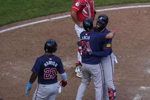 Atlanta Braves' Jorge Soler, right, embraces teammate Orlando Arcia, center, after hitting a 3-run home run during the sixth inning of a baseball game against the Cincinnati Reds, Thursday, Sept. 19, 2024, in Cincinnati. The Braves won 15-3. (AP Photo/Joshua A. Bickel)