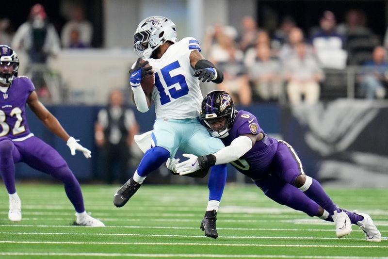 Dallas Cowboys running back Ezekiel Elliott (15) is stopped by Baltimore Ravens linebacker Roquan Smith (0) in the first half of an NFL football game in Arlington, Texas, Sunday, Sept. 22, 2024. (AP Photo/Julio Cortez)