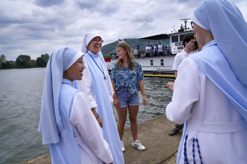 Sisters of the Daughters of Mary Mother of Healing Love in Manchester, N.H., wait along the shores of the Ohio River for the arrival of the Eucharist at the Steubenville Marina, in Steubenville, Ohio, Sunday, June 23, 2024. The sisters are a part of the National Eucharist Pilgrimage caravan, following the East Coast route until it concludes at the National Eucharistic Congress in Indianapolis in mid-July. (AP Photo/Jessie Wardarski)