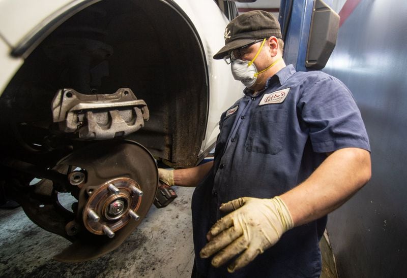 Arron Devoe works on the brakes of a customer’s car at Eddie’s Automotive Service in Lilburn on May 13, 2020. STEVE SCHAEFER / SPECIAL TO THE AJC