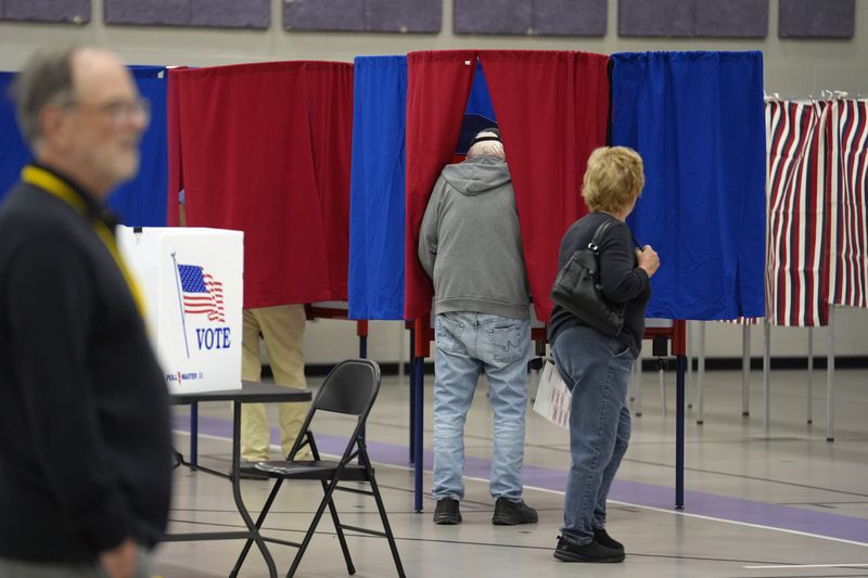 Voters, right, enter booths to fill out ballots Tuesday, Sept. 10, 2024, in Nashua, N.H., in a primary election to pick candidates for governor, the U.S. House, and the state Legislature. (AP Photo/Steven Senne)