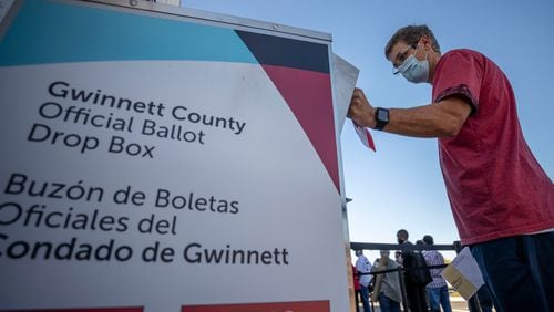 A voter places his ballot inside a drop box on Oct. 13, 2020, the second day of early voting, at the Gwinnett County Voter Registration and Elections building in Lawrenceville. (Alyssa Pointer/Atlanta Journal-Constitution)