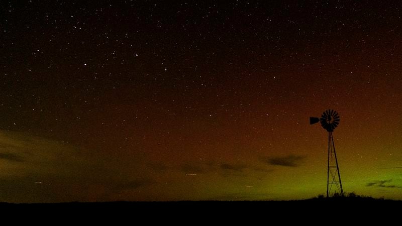 An aurora borealis, also known as the northern lights, is seen in the night sky with the Big Dipper constellation behind a windmill water pump on Tuesday, Sept. 24, 2024, near Washtucna, Wash. (AP Photo/Ted S. Warren)