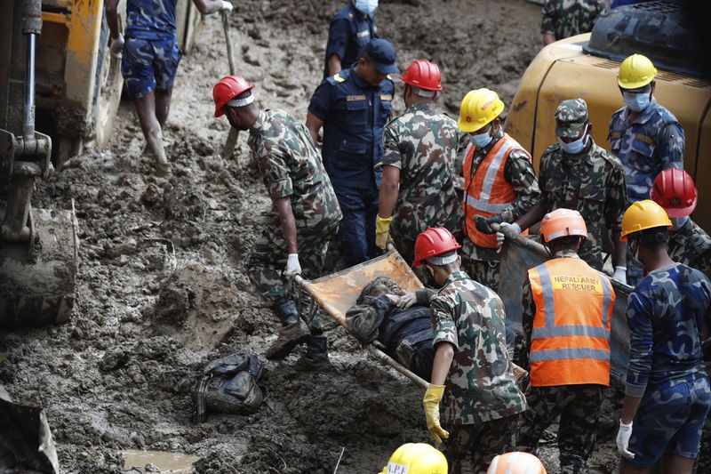 EDS NOTE: GRAPHIC CONTENT - Rescue personnel transport the dead body of a victim who was trapped under a landslide caused by heavy rains in Kathmandu, Nepal, Sunday, Sept. 29, 2024. (AP Photo/Sujan Gurung)