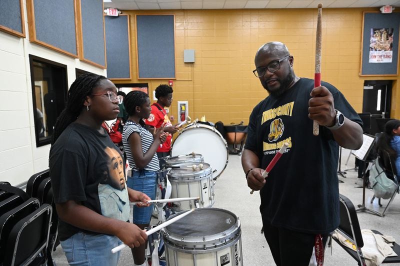 Band director Ernest Stackhouse teaches Aubre Bell, 12, as he leads band practice at Twiggs County High School on a recent afternoon. (Hyosub Shin / AJC)