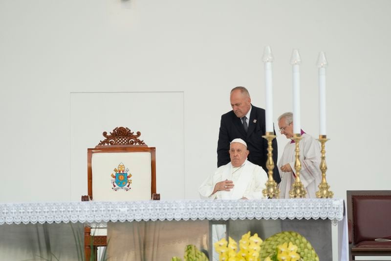 Pope Francis, helped on a wheelchair by assistant Piergiorgio Zanetti, arrives with his aide Bishop Diego Ravelli, right to preside over a memorial mass in the name of Saint Mother Teresa of Calcutta for some 60 thousand faithful inside Jakarta's Gelora Bung Karno stadium, Thursday, Sept. 5, 2024. Francis traveled to Indonesia, at the start of an 11-day, four-nation trip to Asia and Oceania, to encourage Indonesia to combat religiously inspired violence and pledge the Catholic Church's commitment to greater fraternity. (AP Photo/Gregorio Borgia)