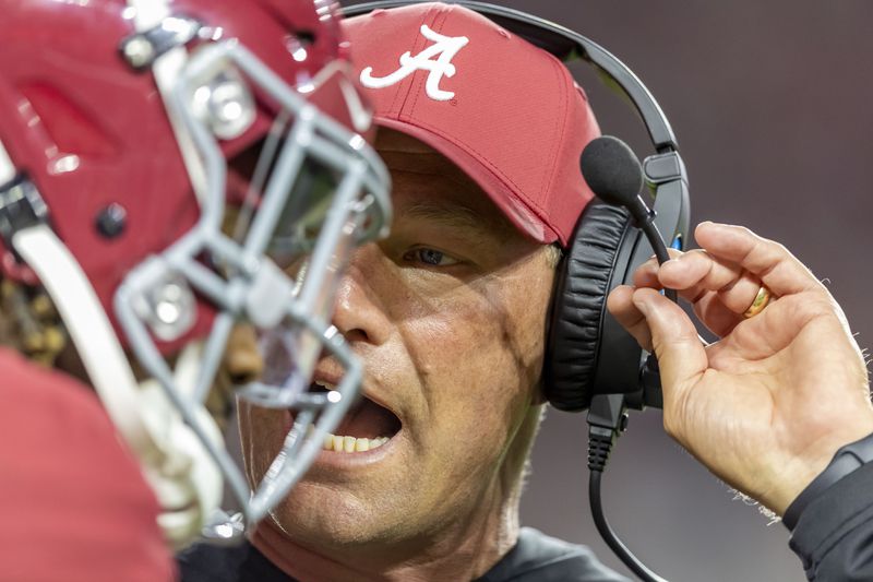 Alabama head coach Kalen DeBoer talks with Alabama quarterback Jalen Milroe between plays during the first half of an NCAA college football game against Georgia, Saturday, Sept. 28, 2024, in Tuscaloosa, Ala. (AP Photo/Vasha Hunt)