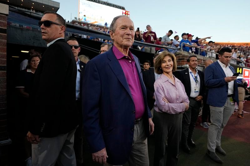 Former President George W. Bush, center left, walks takes the field with his wife Laura Bush, center right, before an NCAA college football game between Florida State and SMU, Saturday, Sept. 28, 2024, in Dallas. (AP Photo/LM Otero)