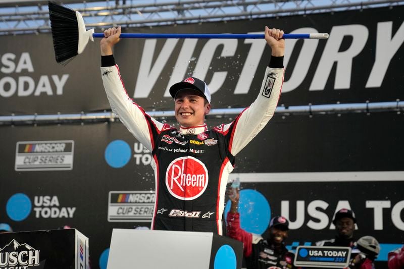 Christopher Bell hold up a broom after winning the NASCAR Cup Series race at New Hampshire Motor Speedway, Sunday, June 23, 2024, in Loudon, N.H. (AP Photo/Steven Senne)