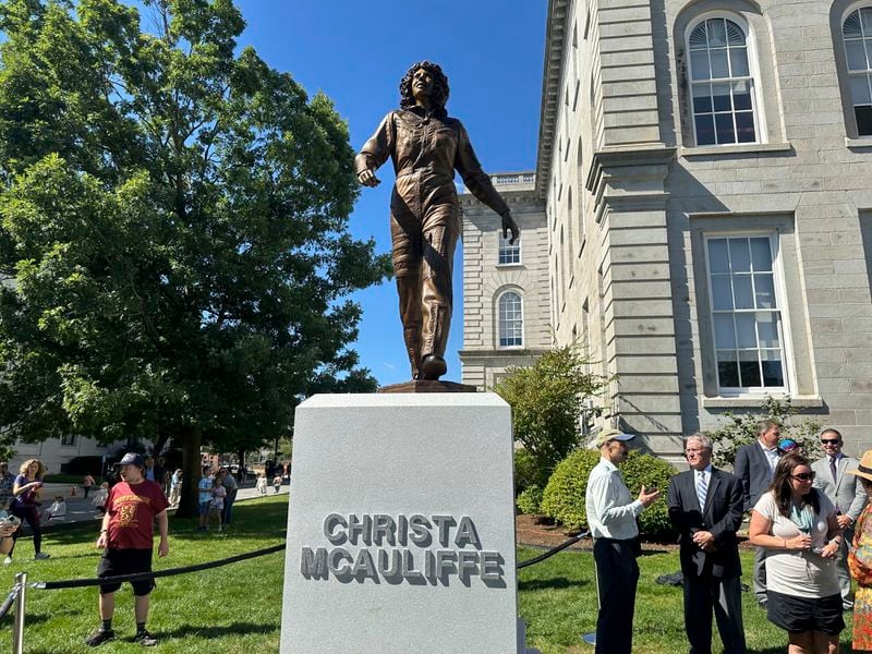 Sculptor Benjamin Victor (in baseball cap) speaks to Steven McAuliffe, former husband of teacher Christa McAuliffe who died when the space shuttle Challenger broke apart in 1986, as they stand next to a statue unveiled on what would've been Christa McAuliffe's 76th birthday, Monday, Sept. 2, 2024, in Concord, N.H. (AP Photo/Nick Perry)