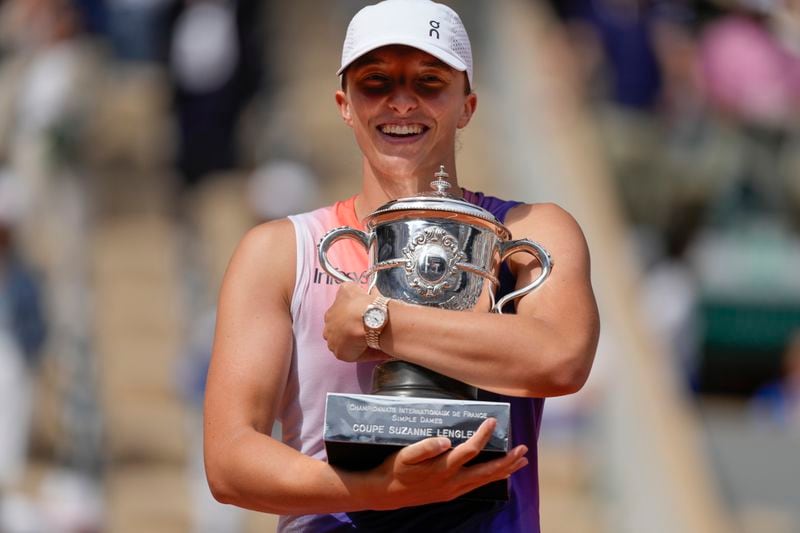 Poland's Iga Swiatek holds the trophy after winning the women's final of the French Open tennis tournament against Italy's Jasmine Paolini at the Roland Garros stadium in Paris, France, Saturday, June 8, 2024. (AP Photo/Thibault Camus)