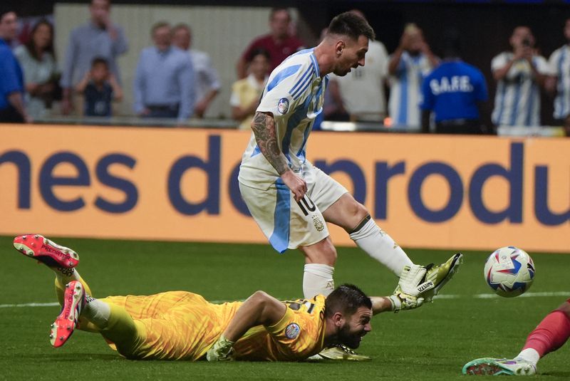Argentina's Lionel Messi, above, and Canada's goalkeeper Maxime Crepeau battle for the ball during a Copa America Group A soccer match in Atlanta, Thursday, June 20, 2024. (AP Photo/Mike Stewart)
