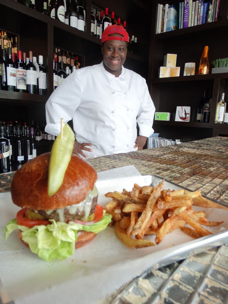 T Gregoire with her high-end TBM burger at Three Blind Mice in Lilburn. CREDIT: Rodney Ho/rho@ajc.com