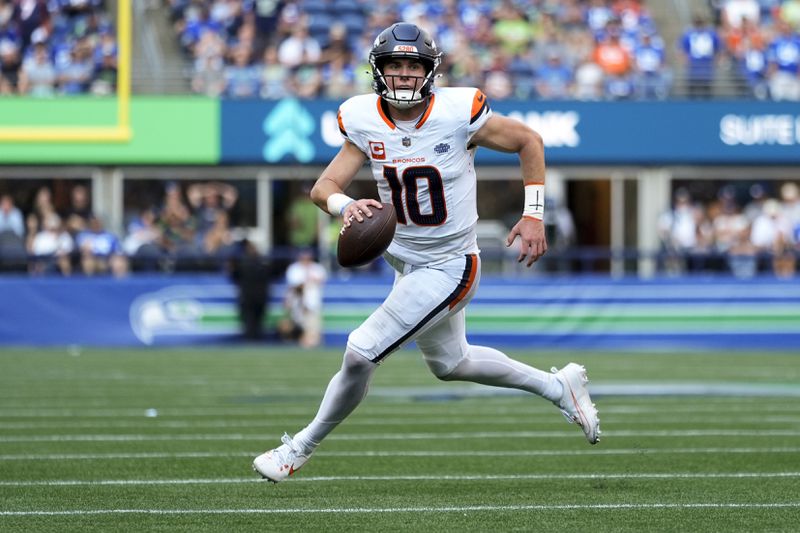 Denver Broncos quarterback Bo Nix (10) runs for a touchdown during the second half of an NFL football game against the Seattle Seahawks, Sunday, Sept. 8, 2024, in Seattle. (AP Photo/Lindsey Wasson)