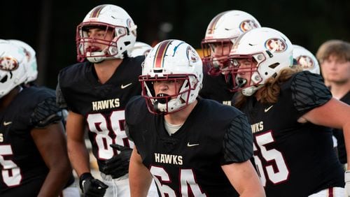 Mill Creek's #64, Eli Richards, and the team take the field for the Cedar Grove at Mill Creek HS football game, September 15, 2023. (Jamie Spaar for the Atlanta Jounal Constitution)