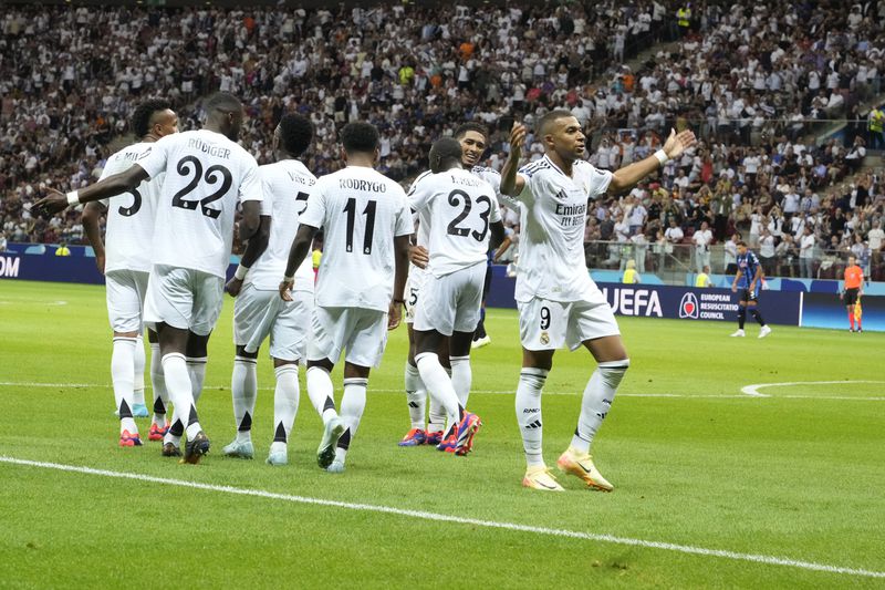 Real Madrid's Kylian Mbappe, right, celebrates after scoring his side's second goal during the UEFA Super Cup Final soccer match between Real Madrid and Atalanta at the Narodowy stadium in Warsaw, Poland, Wednesday, Aug. 14, 2024. (AP Photo/Czarek Sokolowski)