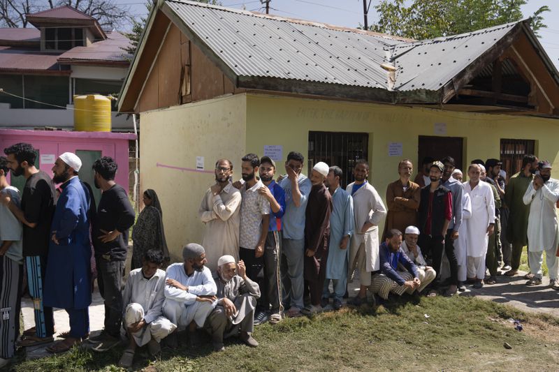 People queue up at a polling booth to cast their vote in Bellow, south of Srinagar, Indian controlled Kashmir, Wednesday, Sept. 18, 2024. (AP Photo/Dar Yasin)