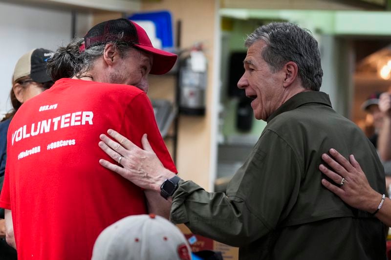 North Carolina governor Roy Cooper greets a resident on Thursday, Oct. 3, 2024, in Boone, N.C. in the aftermath of hurricane Helene. In the final weeks of the presidential election, people in North Carolina and Georgia, influential swing states, are dealing with more immediate concerns: recovering from Hurricane Helene. (AP Photo/Chris Carlson)