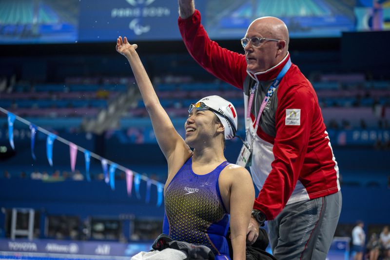 Paralympic athlete Pin Siu Yip, of Singapore, celebrates her victory at the Women's 100m backstroke -S2 final, during the 2024 Paralympics, Thursday, Aug. 29, 2024, in Paris, France. (AP Photo/Emilio Morenatti)