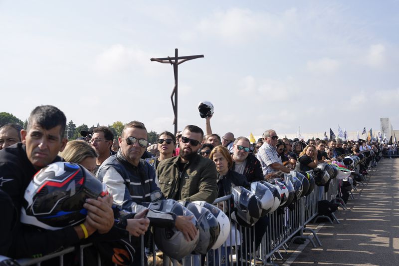 Motorcyclists holding their helmets gather at the Roman Catholic holy shrine of Fatima to attend the IX Pilgrimage of the Blessing of Helmets that draws tens of thousands, in Fatima, Portugal, Sunday, Sept. 22, 2024. (AP Photo/Ana Brigida)