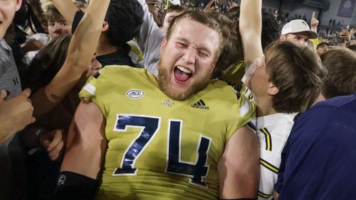Georgia Tech Yellow Jackets offensive lineman Tyler Gibson (74) and other Georgia Tech players celebrate their win over North Carolina and fans storm the field fter a NCAA football game In Atlanta on Saturday, Oct. 28, 2023 between the Georgia Tech Yellow Jackets and the North Carolina Tar Heels.  Georgia Tech won, 46-42.  (Bob Andres for the Atlanta Journal Constitution)