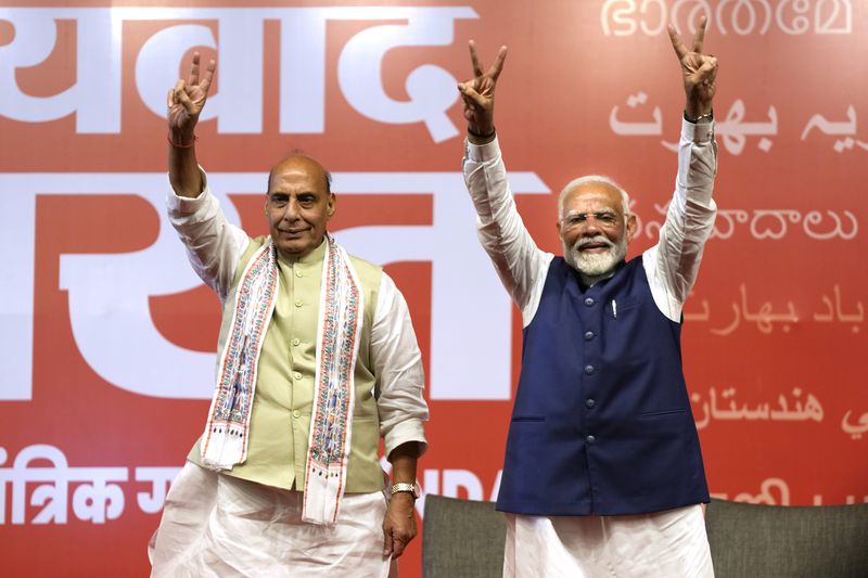 Indian prime Minister Narendra Modi celebrates with Defense Minister Rajnath Singh on result day at the Bharatiya Janta Party headquarters, in New Delhi, India, Tuesday, June 4, 2024. Wednesday's shock election results showed that Modi’s party had fallen short of the 272 majority mark needed to form the government on their own, bagging 240 seats. Instead, Modi now needs his coalition National Democratic Alliance, which won the majority of 292 contests, to retain his grip over the world’s most populous nation. (AP Photo/Manish Swarup)
