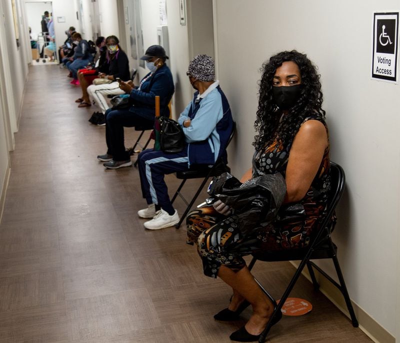 Xavier Benjamin (R) waits to vote at the South Fulton Service Center early on Friday morning, May 22, 20220. Benjamin said she arrived at the center at 6:20 am to secure her first place in line. STEVE SCHAEFER FOR THE AJC