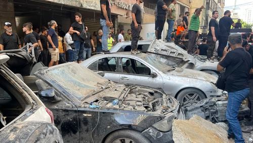 People gather at the scene of an Israeli missile strike in the southern suburbs of Beirut, Friday, Sept. 20, 2024. (AP Photo/Bilal Hussein)