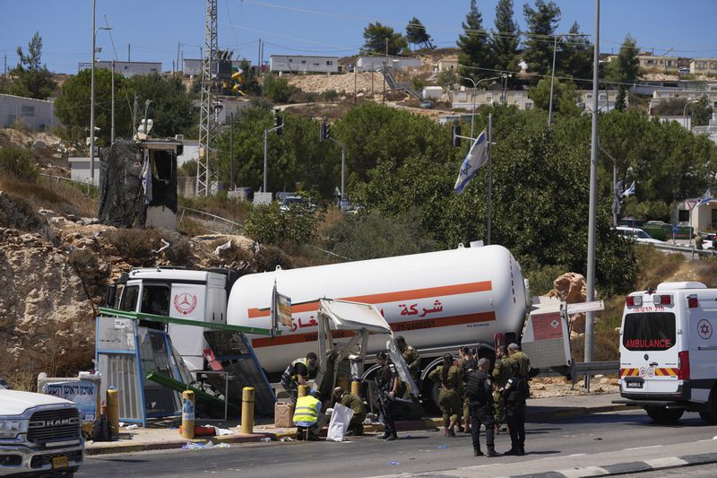 Israeli security forces inspect the scene of what they say is a Palestinian ramming attack at a bus station near the West Bank Jewish settlement of Beit El, Wednesday, Sept. 11, 2024. (AP Photo/Ohad Zwigenberg)