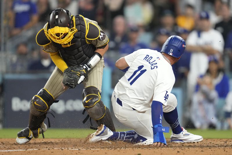 Los Angeles Dodgers' Miguel Rojas (11) is forced out at home plate by San Diego Padres catcher Kyle Higashioka, left, after a ground ball by Freddie Freeman during the fourth inning in Game 1 of baseball's NL Division Series, Saturday, Oct. 5, 2024, in Los Angeles. (AP Photo/Ashley Landis)