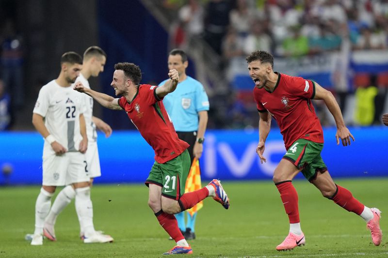 Portugal players celebrate their win in penalties shootouts after a round of sixteen match between Portugal and Slovenia at the Euro 2024 soccer tournament in Frankfurt, Germany, Monday, July 1, 2024. (AP Photo/Matthias Schrader)