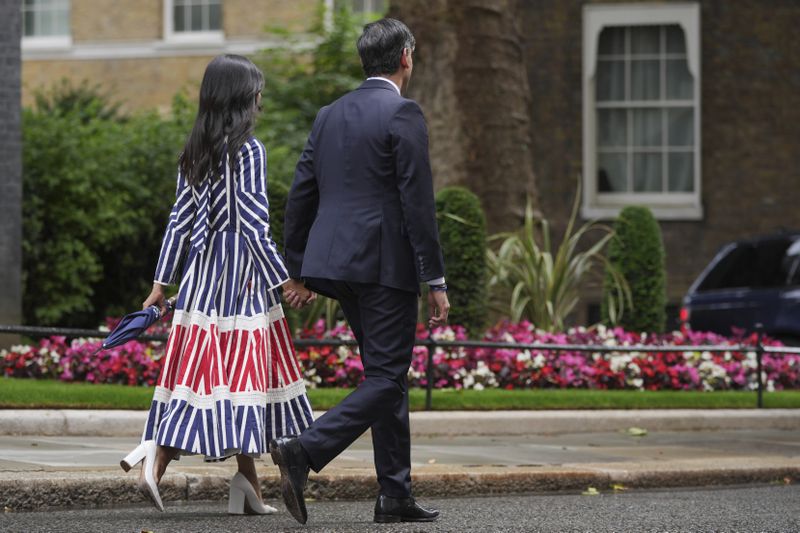 Britain's outgoing Conservative Party Prime Minister Rishi Sunak and his wife Akshata Murty walk from 10 Downing Street to a waiting car before going to see King Charles III to tender his resignation in London, Friday, July 5, 2024. Sunak and his Conservative Party lost the general election held July 4, to the Labour Party, whose leader Keir Starmer is set become Prime Minister later Friday. (AP Photo/Kin Cheung)