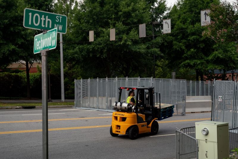 Workers install temporary fencing on 10th street at Techwood Drive NW on Thursday, June 27, 2024 (Ben Hendren for the Atlanta Journal-Constitution)