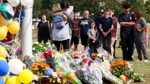 Mourners visit a memorial on Sept. 6 at Apalachee High. Students around Georgia have planned walkouts for tougher gun safety laws. (Jason Getz/The Atlanta Journal-Constitution/TNS)