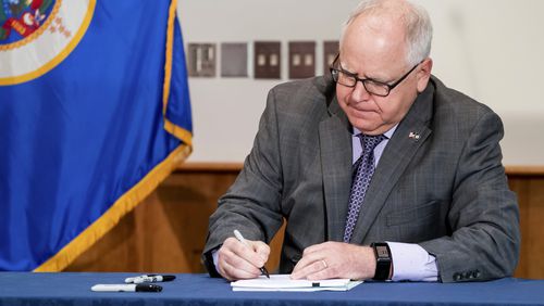 FILE - Gov. Tim Walz signs into law a sweeping package of police accountability measures in St. Paul, Minn., on July 23, 2020, including a ban on neck restraints, in the wake of George Floyd's death. (Glen Stubbe/Star Tribune via AP, File)