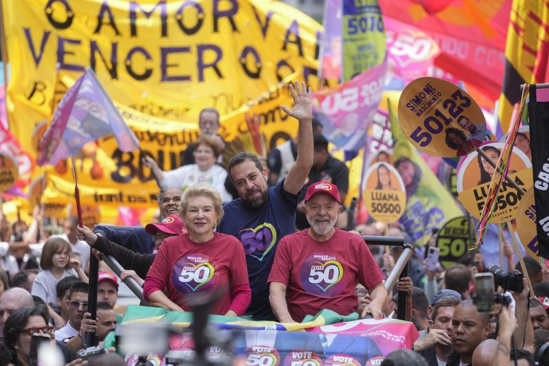 Mayoral candidate Guilherme Boulos of the Socialism and Liberty Party, center, campaigns with Brazilian President Luiz Inacio Lula da Silva, right, and his running mate Marta Suplicy, left, the day before elections in Sao Paulo, Saturday, Oct. 5, 2024. (AP Photo/Andre Penner)