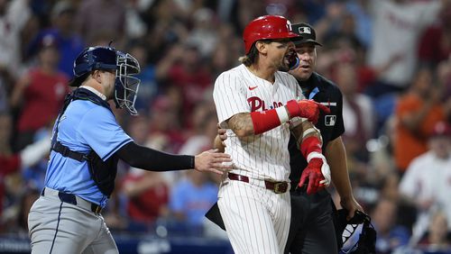 Philadelphia Phillies' Nick Castellanos, center right, reacts after he was hit by a pitch from Tampa Bay Rays' Edwin Uceta as Logan Driscoll, left, and umpire John Libka hold back Castellanos during the eighth inning of a baseball game, Tuesday, Sept. 10, 2024, in Philadelphia. (AP Photo/Derik Hamilton)