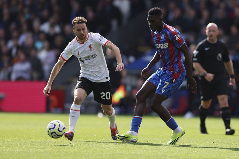 Liverpool's Diogo Jota, left, and Crystal Palace's Ismaila Sarr challenge for the ball the English Premier League soccer match between Crystal Palace and Liverpool at Selhurst Park in London, Saturday, Oct. 5, 2024.(AP Photo/Ian Walton)