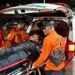 Rescuers transfer a survivor into an ambulance after a landslide set off by torrential rains smashed down into an unauthorized gold mining operation, killing several people, in Solok, West Sumatra, Indonesia, Saturday, Sept. 28, 2024. (AP Photo/John Nedy)