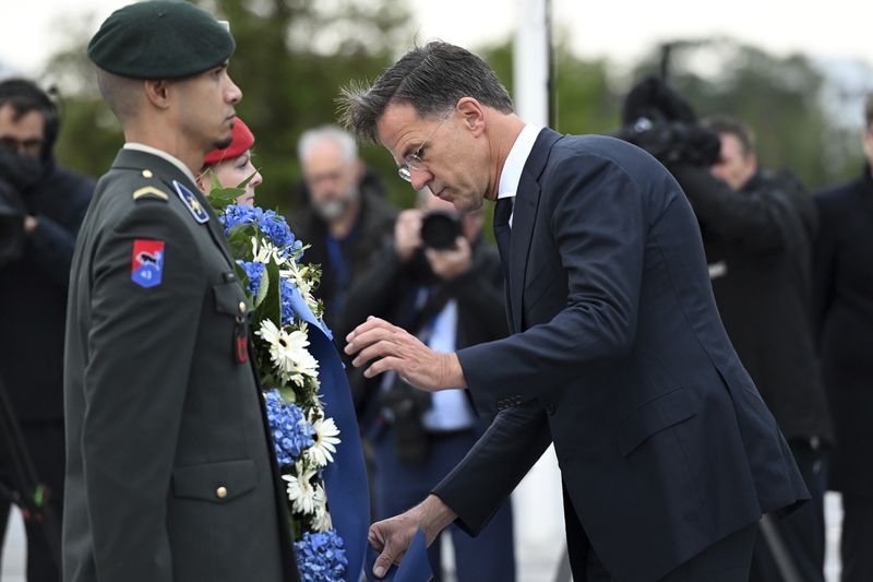 The incoming NATO Secretary General Mark Rutte lays a wreath during a transition ceremony at NATO headquarters in Brussels, Belgium, Tuesday, Oct. 1, 2024. (AP Photo/Harry Nakos)