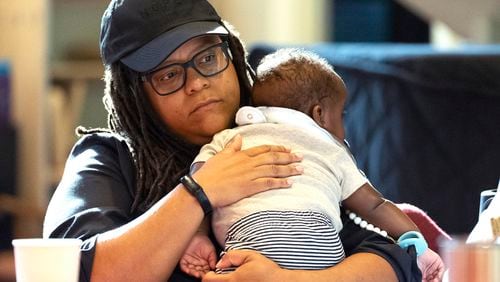 Georgia State Sen. Kim Jackson holds her son as she takes part in a reproductive health town hall meeting at Neighborhood Church Thursday, Aug. 29, 2024, in Atlanta. (AP Photo/John Bazemore)