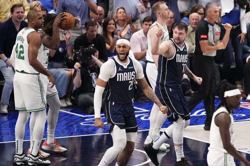 Dallas Mavericks center Daniel Gafford (21) and guard Luka Doncic (77) celebrate a play during the first half in Game 4 of the NBA basketball finals against the Boston Celtics, Friday, June 14, 2024, in Dallas. (AP Photo/Sam Hodde)